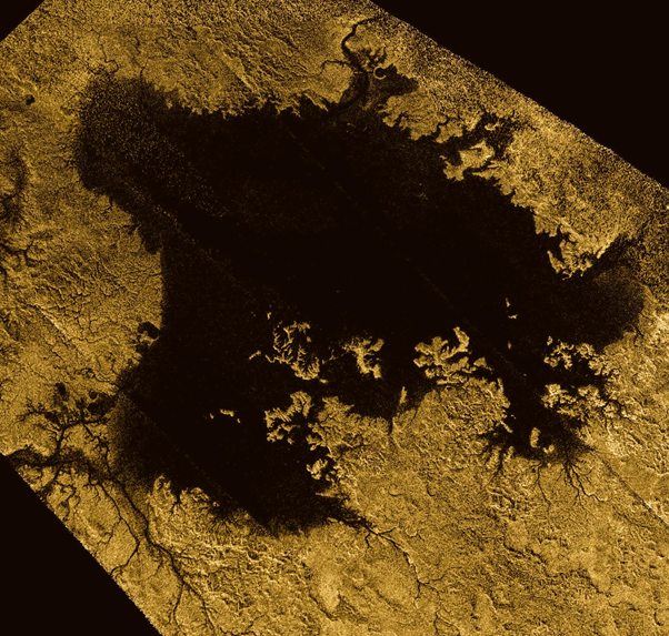 Fotografia obtida pela sonda Cassini da NASA da superfície de Titã. Nela podemos ver um lago (provavelmente de hidrocarboneto) citado no texto.